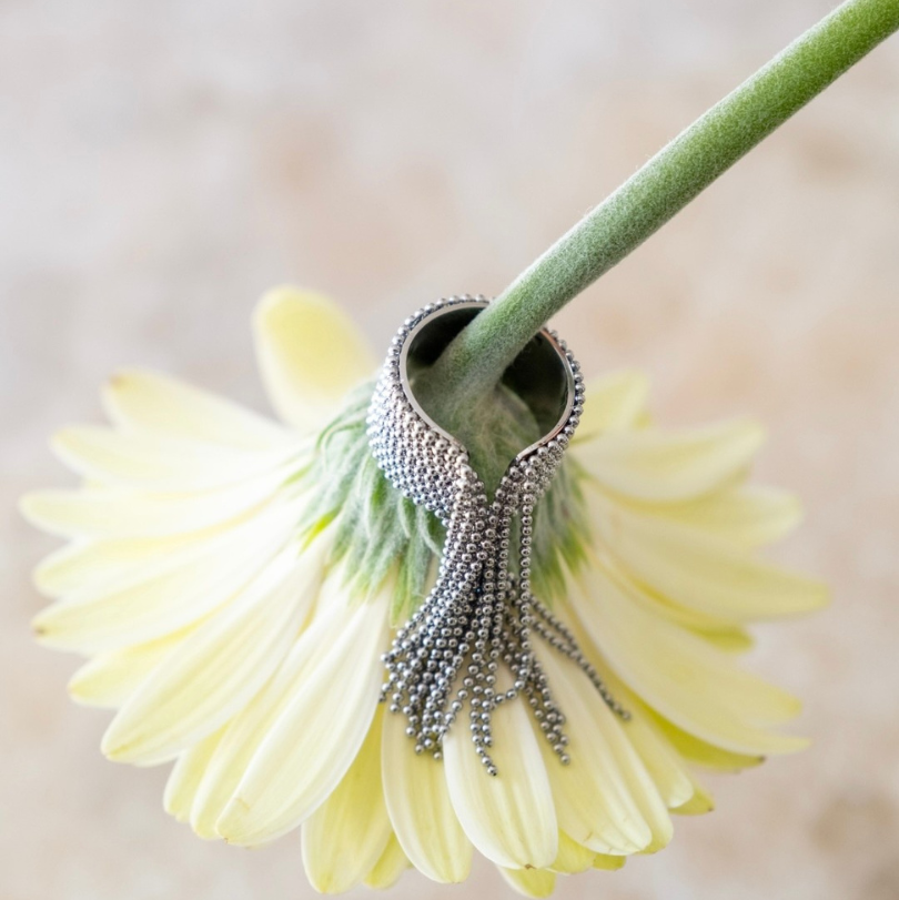 Silver fringe ring on a yellow flower 